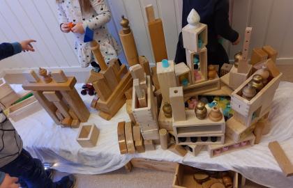Byggverk med tårn og portaler av lekeklosser stående på et bord i lekeområdet