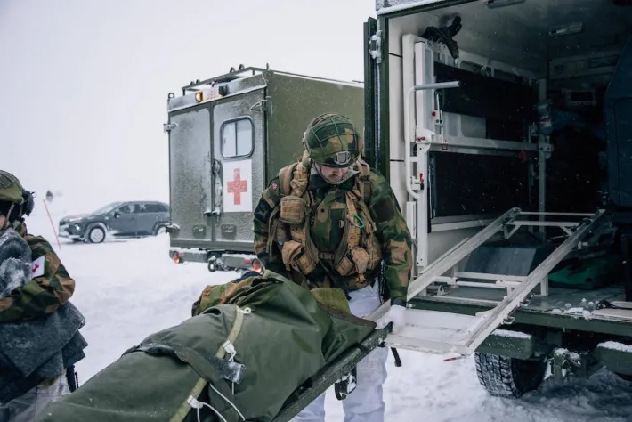 Norsk sanitetssoldat øver på å frakte skadd medsoldat på båre