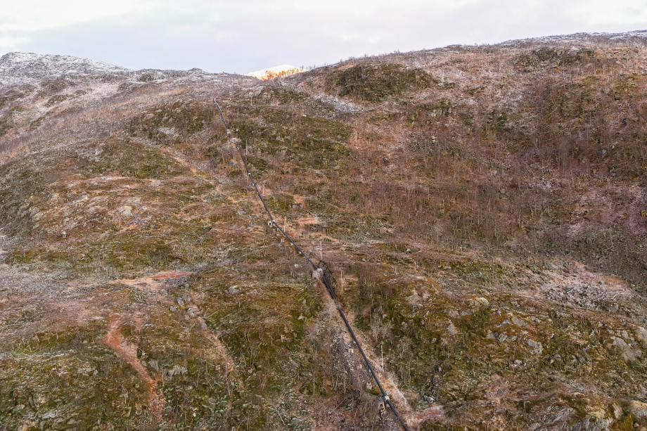 Viser ledninger som går ned fra Damvatnet på Ringvassøya til minikraftverket i havkanten.