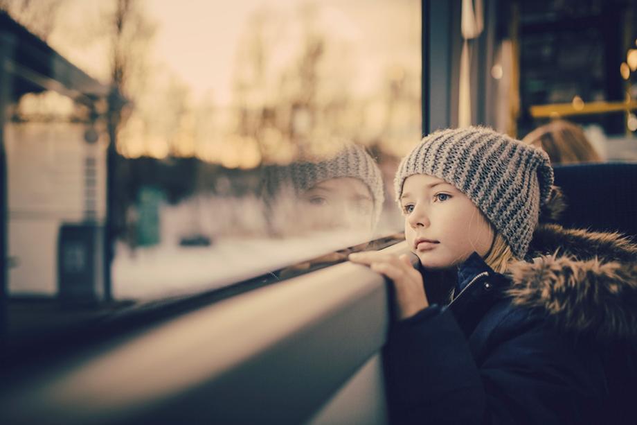 Illustrasjonsbilde - jente kikker ut av vinduet på en buss