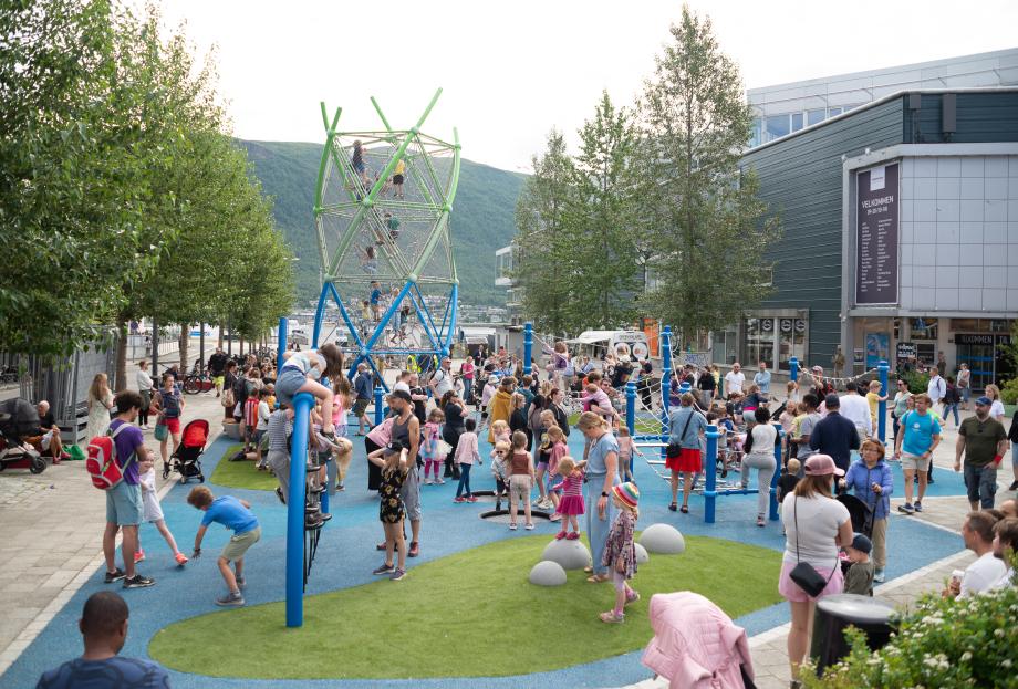 Oversiktsbilde som viser Strandtorget lekeplass og barn som leker under den offisielle åpningen av lekeplassen..