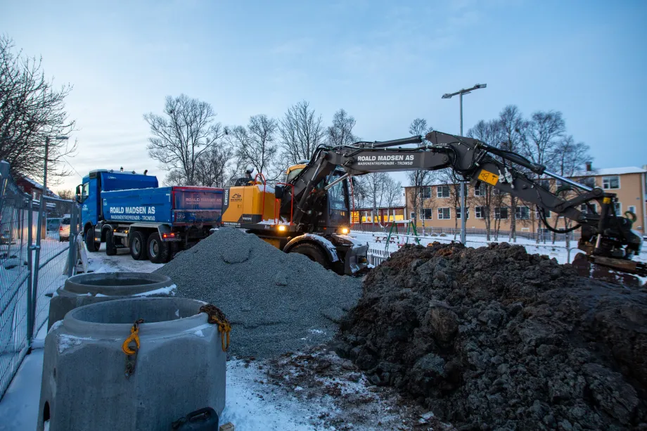 Gravemaskin og lastebil i arbeid.