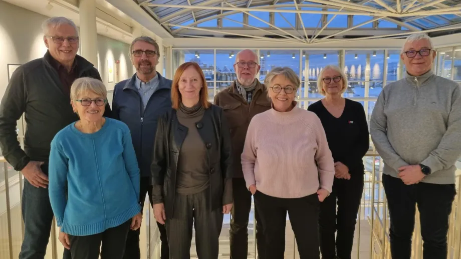 &Aring;tte eldrer&aring;dsmedlemmer st&aring;r inne p&aring; r&aring;dhuset. Smiler til kamera.