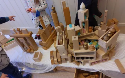 Byggverk med t&aring;rn og portaler av lekeklosser st&aring;ende p&aring; et bord i lekeomr&aring;det