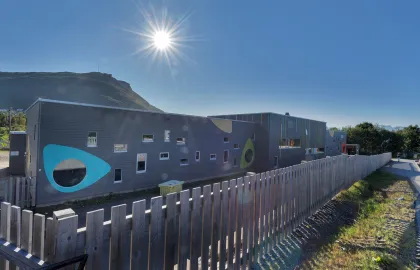 Elvestrand barnehage sett utenfra en solrik sommerdag med blå himmel