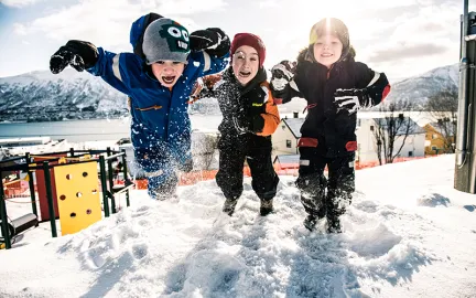 Gyllenvang barnehage vinter Tre glde barn hopper i snøen i Gyllenvang barnehage