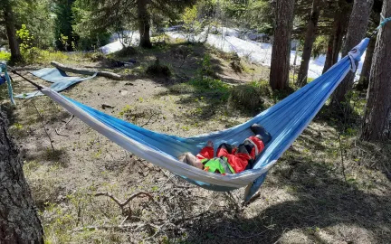 Hamna friluftsbarnehage barn som ligger i hengek&oslash;ye i skogen en solrik sommerdag