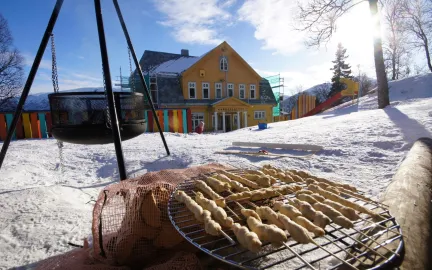 Grilling av pinnebr&oslash;d uten for barnehagen en solrik vinterdag