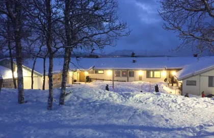 Kvaløysletta barnehage sett utenfra en snørik vinterdag i blåtimen