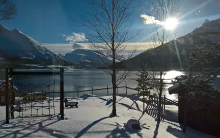 Uteomr&aring;det i Lakselvbukt barnehage en str&aring;lende vinterdag med sol, hav og fjell
