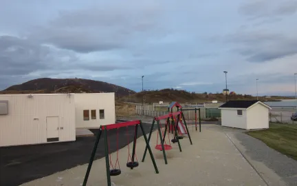 Sommar&oslash;y barnehage uteomr&aring;de med husker og sandkasse en sommerdag