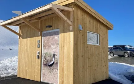 Slik ser et av Troms&oslash; kommunes friluftstoalett ut. Her er toalettd&oslash;ren utsmykket med fotografi av en fuggel.