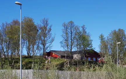 Ameliahaugen barnehage sett utenfra en fin sommerdag med tr&aelig;r og bl&aring; himmel