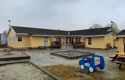 Uteområde med sandkasse, benker og bord i Polarhagen barnehage