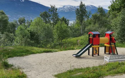 Lekeomr&aring;det med klatret&aring;rn og sandkasse en sommerdag i Soldagen barnehage
