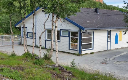 Soldagen barnehage sett utenfra med skog og gr&oslash;nt gress en sommerdag
