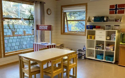 Inneomr&aring;de med kiosk, bord og hyller i Toftveien barnehage