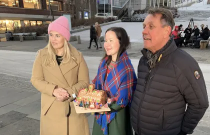 Kristina Torbergsen, Maja Kristine Jåma og Gunnar Wilhelmsen på Stortorget. Jåma, i midten, holder et pepperkakehus påskrevet Samisk hus.