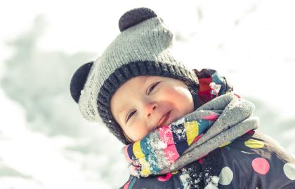 Bilde som viser et smilende barn i vinterlek