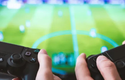 Gaming med to playstation-stikker og Fifa på skjerm