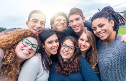 Bilde som viser åtte smilende personer som omfavner hverandre