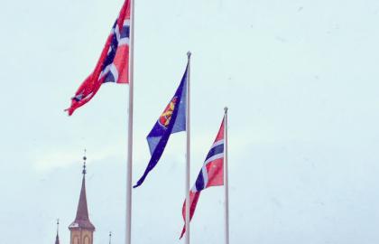 To norske og et kvensk flagg vaier utenfor Tromsø rådhus i mars 2019