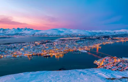 Panoramabilde av et snøkledt Tromsøya tatt fra fjellheisen i Tromsdalen.