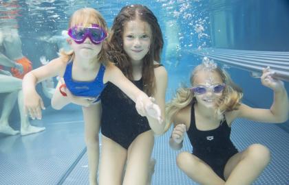 Tre glade jenter som har dykket under vann på Tromsøbadet