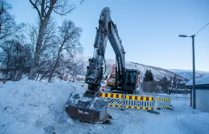 Gravemaskin i vei ved grøft