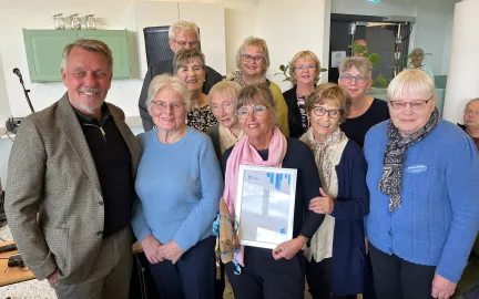 Ordf&oslash;reren, eldrer&aring;dslederen og Karmas Klubb st&aring;r oppstilt. Smiler til kamera.