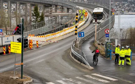 Arbeidere i gule kl&aelig;r jobber i gangveien p&aring; Troms&oslash;brua
