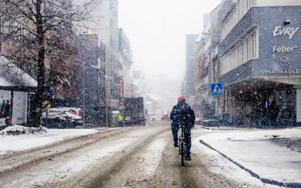 Syklist i bygate i lett sn&oslash;v&aelig;r