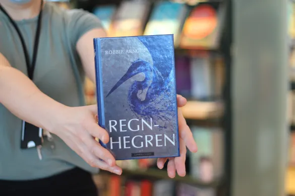 Forsiden av en bok. Fargen er s&oslash;lv, og en hegre er illustrert i bl&aring;tt. Foto.