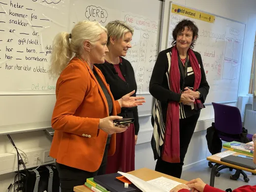 Rektor ved voksenoppl&aelig;ringen Lena Steinsvik Hansen, arbeids- og inkluderingsminister Marte Mj&oslash;s Persen og spr&aring;kl&aelig;rer Marit N&aelig;svoll foran spr&aring;kklassen st&aring;r fremst i klasserommet under norskoppl&aelig;ringen for innvandrere