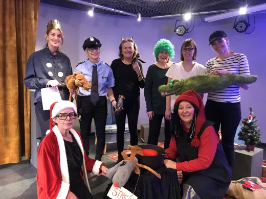 &Aring;tte personer i kostyme smiler mot kamera. Foto.