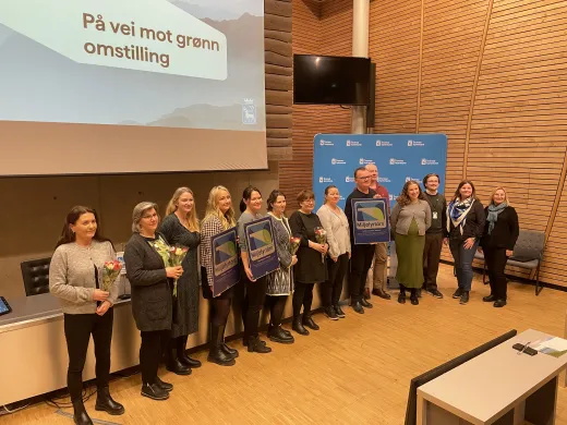 Ansatte og ledere i Troms&oslash; kommunen poserer for fotograf med blomster og milj&oslash;fyrt&aring;rndiplom