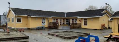 Uteområde med sandkasse, benker og bord i Polarhagen barnehage