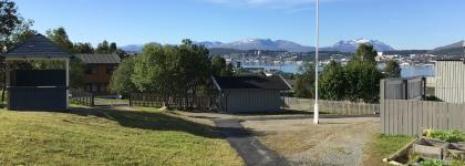 Uteområde Kroken barnehage med utsikt mot Tromsøya en solrik sommerdag